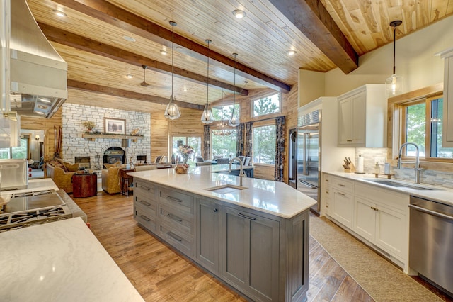 16267 Conners Ln, Sand Lake Twp, WI 54876 - kitchen featuring stainless steel appliances, healthy amount of natural light, gray cabinetry, white cabinetry, and wood walls