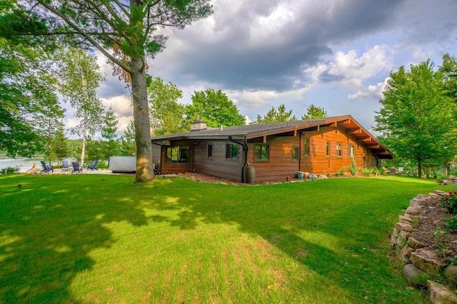 16267 Conners Ln, Sand Lake Twp, WI 54876 - back of property featuring a chimney, a hot tub, and a lawn