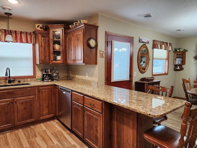 307 14th St N, Cold Spring, MN 56320 - kitchen featuring stainless steel dishwasher, a peninsula, a kitchen breakfast bar, light stone countertops, and a textured ceiling