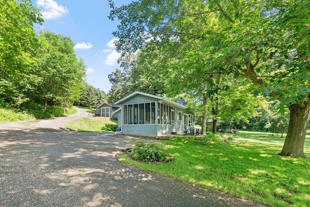 20592 Lehmicke Ln, Trade Lake, WI 54853 - view of front of property featuring a sunroom, a front lawn, a chimney, and gravel driveway