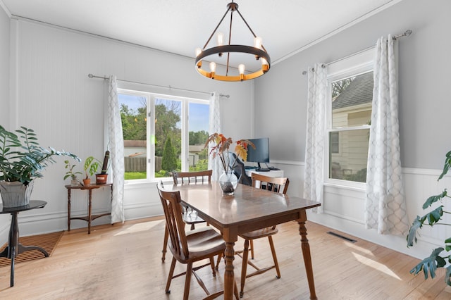 218 11th Ave NE, Rochester, MN 55906 - dining space featuring a chandelier, light wood-type flooring, wainscoting, a decorative wall, and ornamental molding