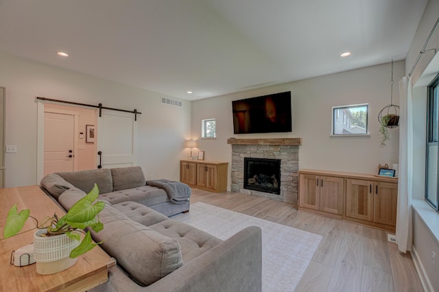 21 Windsor Wood Path, Hudson, WI 54016 - living room with a barn door, healthy amount of natural light, light wood finished floors, recessed lighting, and a stone fireplace