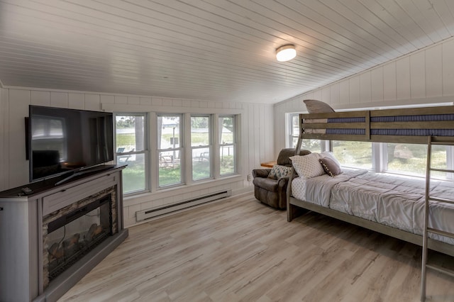 36722 Birch Dr, Jenkins Twp, MN 56474 - bedroom featuring a baseboard heating unit, vaulted ceiling, light wood-style flooring, and a glass covered fireplace
