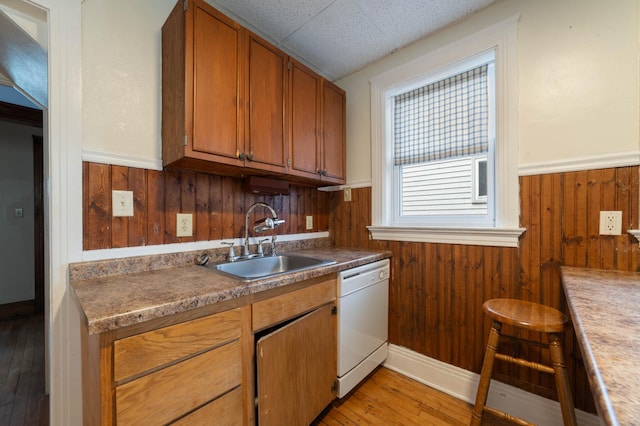 211 Saint Marie St, Duluth, MN 55803 - kitchen with white dishwasher, wainscoting, wood walls, light wood-style flooring, and brown cabinets