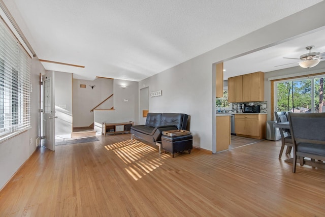 3237 Jerry Ct, White Bear Lake, MN 55110 - living room with light wood finished floors, ceiling fan, and stairway