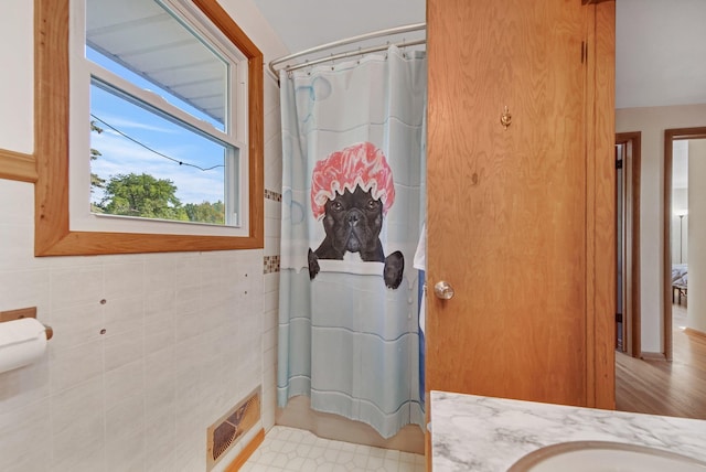 3237 Jerry Ct, White Bear Lake, MN 55110 - full bathroom with vanity, a shower with shower curtain, and tile walls
