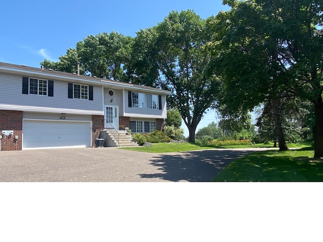 7685 Afton Ct, Woodbury, MN 55125 - raised ranch featuring brick siding, asphalt driveway, and a garage