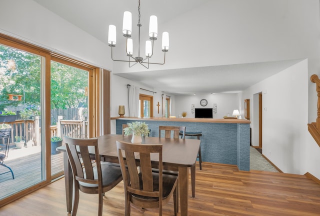 12145 Jonquil St NW, Coon Rapids, MN 55433 - dining room featuring wood finished floors, a chandelier, and a towering ceiling