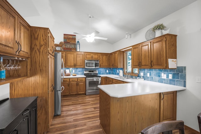 12145 Jonquil St NW, Coon Rapids, MN 55433 - kitchen featuring stainless steel appliances, vaulted ceiling, a peninsula, ceiling fan, and decorative backsplash