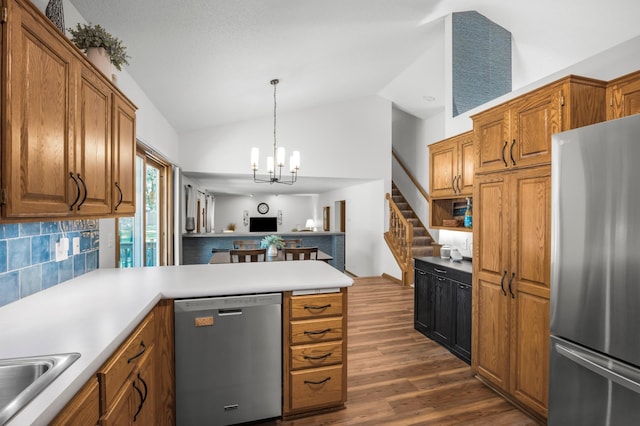 12145 Jonquil St NW, Coon Rapids, MN 55433 - kitchen featuring stainless steel appliances, a chandelier, vaulted ceiling, tasteful backsplash, and a peninsula