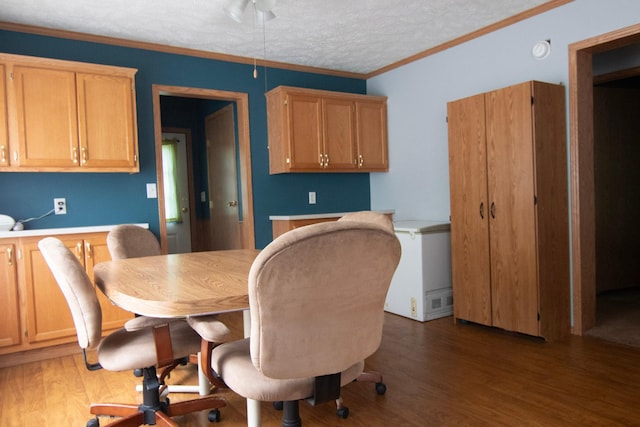 23829 Bulrush Dr, Lake Edward Twp, MN 56465 - dining room featuring ceiling fan, wood finished floors, a textured ceiling, built in desk, and crown molding
