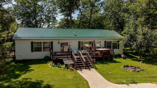23829 Bulrush Dr, Lake Edward Twp, MN 56465 - view of front of house featuring a deck, a front lawn, a fire pit, a metal roof, and stairway