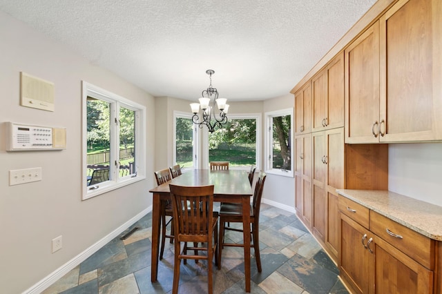 1110 Lecuyer Dr, Stillwater, MN 55082 - dining space featuring stone tile flooring, a chandelier, and a textured ceiling