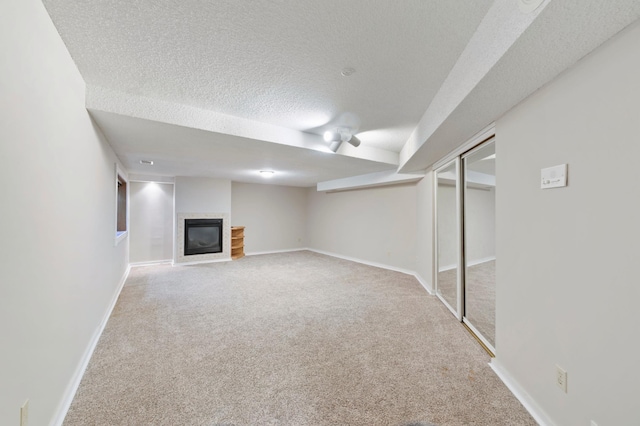 1110 Lecuyer Dr, Stillwater, MN 55082 - finished basement with carpet flooring, a textured ceiling, and a glass covered fireplace