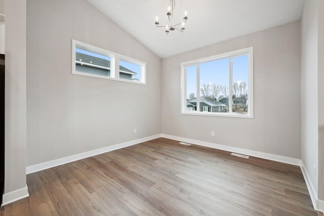 17006 Traprock St NW, Ramsey, MN 55303 - spare room featuring a chandelier, wood finished floors, and lofted ceiling