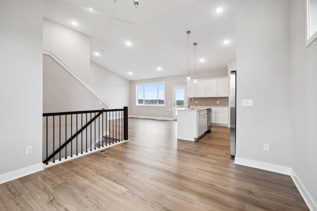 17006 Traprock St NW, Ramsey, MN 55303 - kitchen featuring open floor plan, white cabinetry, light countertops, a kitchen island with sink, and light wood finished floors