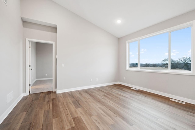 17006 Traprock St NW, Ramsey, MN 55303 - unfurnished room with vaulted ceiling, wood finished floors, and recessed lighting