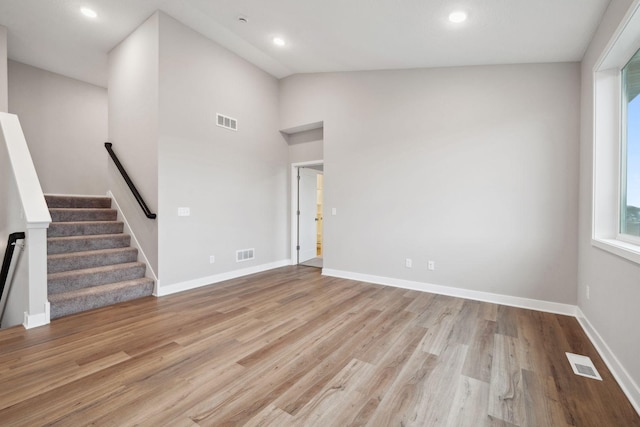 17006 Traprock St NW, Ramsey, MN 55303 - unfurnished living room featuring light wood-style flooring, stairs, recessed lighting, and vaulted ceiling