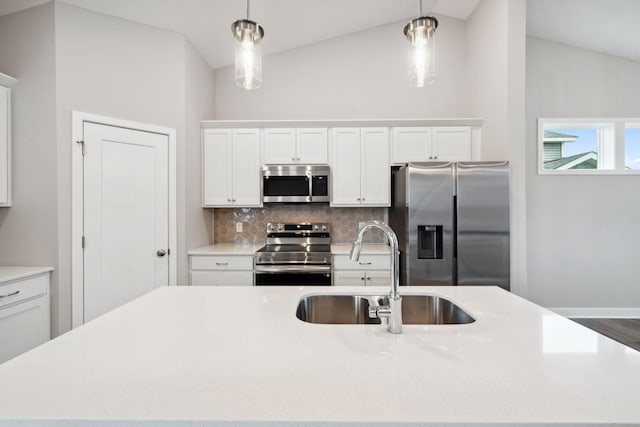 17006 Traprock St NW, Ramsey, MN 55303 - kitchen with appliances with stainless steel finishes, lofted ceiling, a kitchen island with sink, backsplash, and white cabinetry