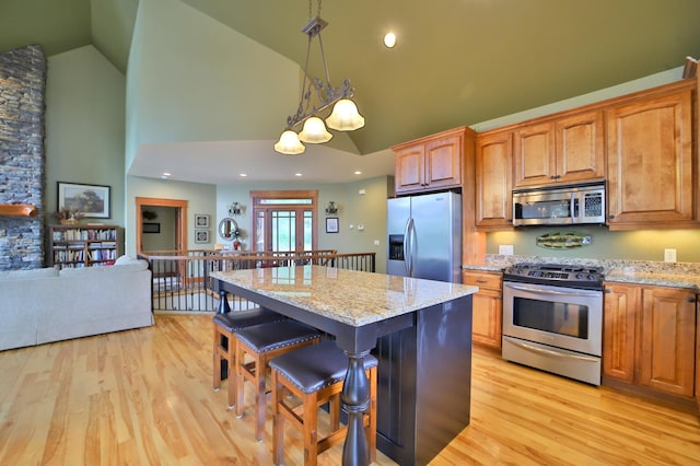 2471 Birch Forest Rd SW, Nisswa, MN 56468 - kitchen featuring stainless steel appliances, high vaulted ceiling, a kitchen bar, light stone countertops, and a center island