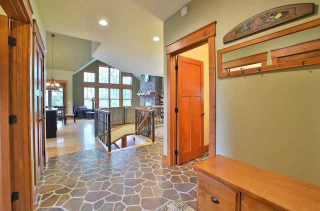 2471 Birch Forest Rd SW, Nisswa, MN 56468 - hallway with a chandelier, an upstairs landing, recessed lighting, lofted ceiling, and stone finish floors