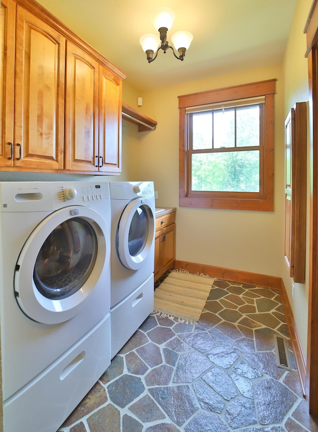 2471 Birch Forest Rd SW, Nisswa, MN 56468 - laundry room featuring cabinet space, washer and dryer, a chandelier, and stone finish floors