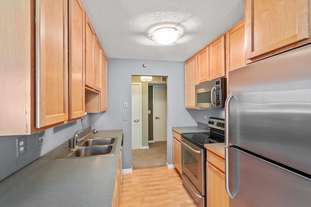 48 Groveland Ter Unit B301, Minneapolis, MN 55403 - kitchen featuring stainless steel appliances, a textured ceiling, and light wood finished floors