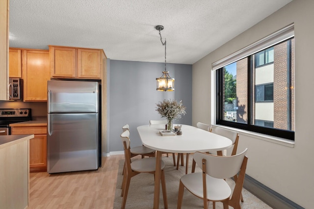 48 Groveland Ter Unit B301, Minneapolis, MN 55403 - dining room with light wood-style flooring, a textured ceiling, and a chandelier