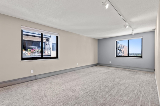 48 Groveland Ter Unit B301, Minneapolis, MN 55403 - carpeted empty room with a textured ceiling, track lighting, and baseboard heating