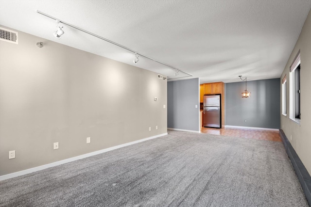 48 Groveland Ter Unit B301, Minneapolis, MN 55403 - unfurnished room featuring rail lighting, light carpet, and a textured ceiling