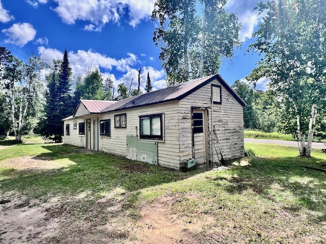 8931 Palm Rd, Britt, MN 55710 - view of home's exterior featuring a lawn and a metal roof
