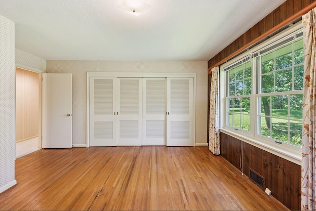 33 Eagle Ridge Rd, North Oaks, MN 55127 - unfurnished bedroom with wallpapered walls, light wood-type flooring, and a closet