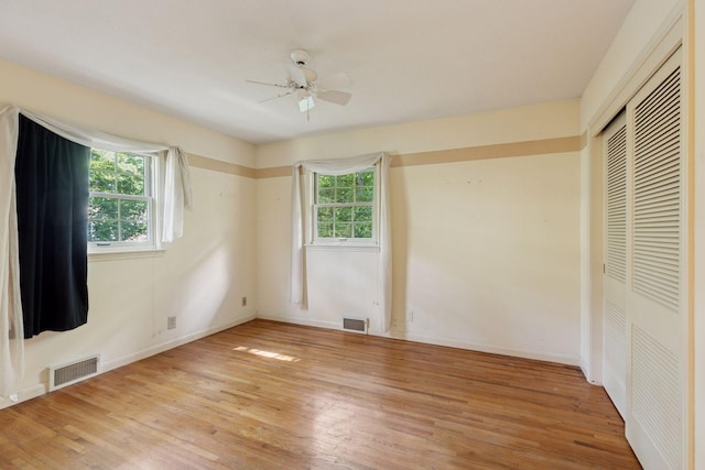 33 Eagle Ridge Rd, North Oaks, MN 55127 - unfurnished bedroom featuring multiple windows, light wood-style floors, a closet, and a ceiling fan