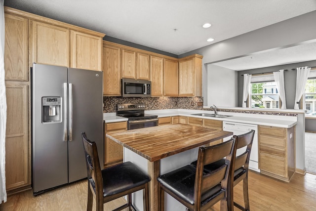 2079 Clover Ridge Dr, Chaska, MN 55318 - kitchen with stainless steel appliances, wood counters, a peninsula, light wood-style floors, and decorative backsplash