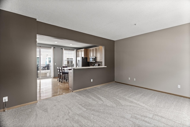 2079 Clover Ridge Dr, Chaska, MN 55318 - unfurnished living room featuring light carpet, a textured ceiling, and recessed lighting