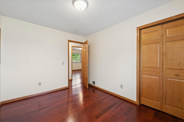 629 73rd Way N, Brooklyn Park, MN 55444 - empty room featuring dark wood-type flooring and a textured ceiling
