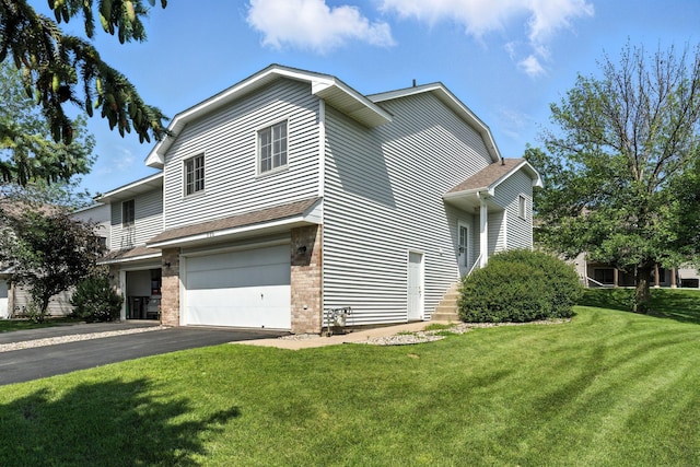 900 Countryside Rd, Waconia, MN 55387 - view of property exterior featuring a lawn, an attached garage, asphalt driveway, and brick siding