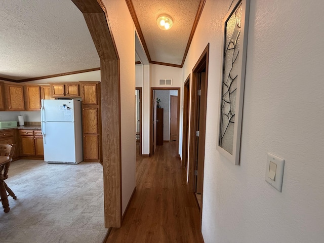 151 Skyline Dr, Granite Falls, MN 56241 - hallway featuring a textured ceiling, vaulted ceiling, a textured wall, and wood finished floors