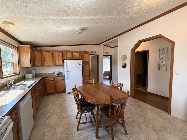 151 Skyline Dr, Granite Falls, MN 56241 - kitchen with white appliances, ornamental molding, brown cabinets, plenty of natural light, and arched walkways
