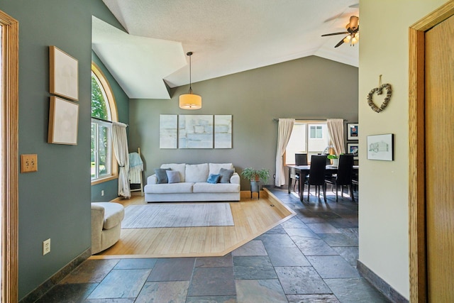 4478 150th St, Savage, MN 55378 - living area featuring vaulted ceiling, stone tile flooring, plenty of natural light, and a ceiling fan