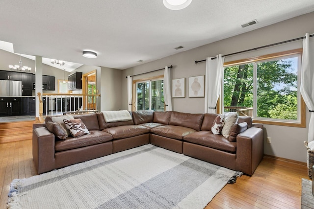 4478 150th St, Savage, MN 55378 - living room with light wood-style floors, a chandelier, and a textured ceiling