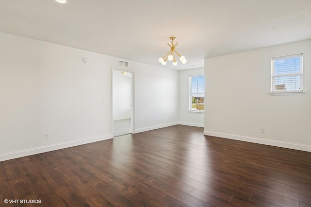 3618 112th Cir NE, Blaine, MN 55449 - empty room featuring a chandelier, healthy amount of natural light, and dark wood-style floors