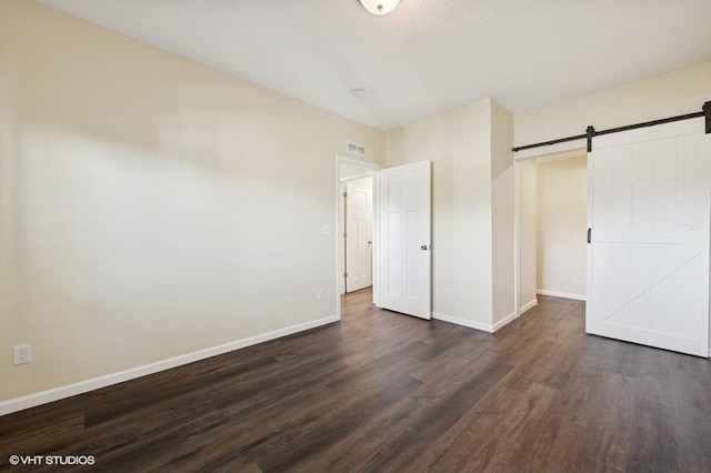 3618 112th Cir NE, Blaine, MN 55449 - unfurnished bedroom with dark wood-style flooring and a barn door