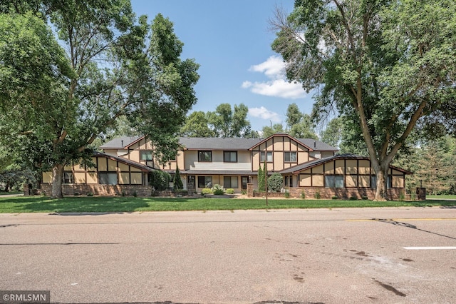 1111 Royal Oaks Dr, Shoreview, MN 55126 - tudor house featuring a front yard, uncovered parking, and a sunroom