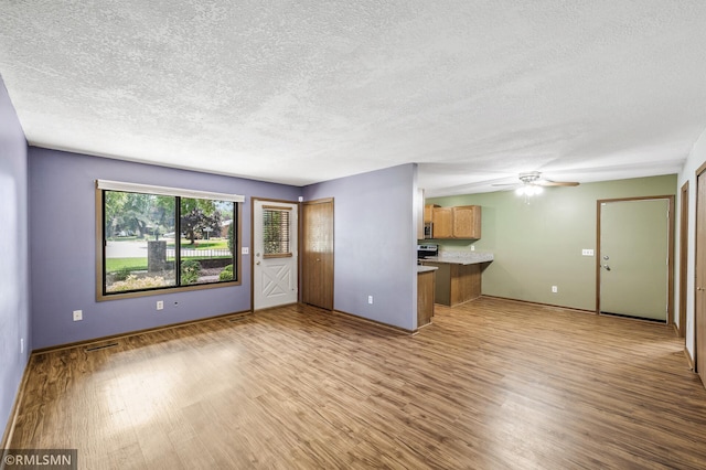 1111 Royal Oaks Dr, Shoreview, MN 55126 - unfurnished living room with wood finished floors, a textured ceiling, and a ceiling fan