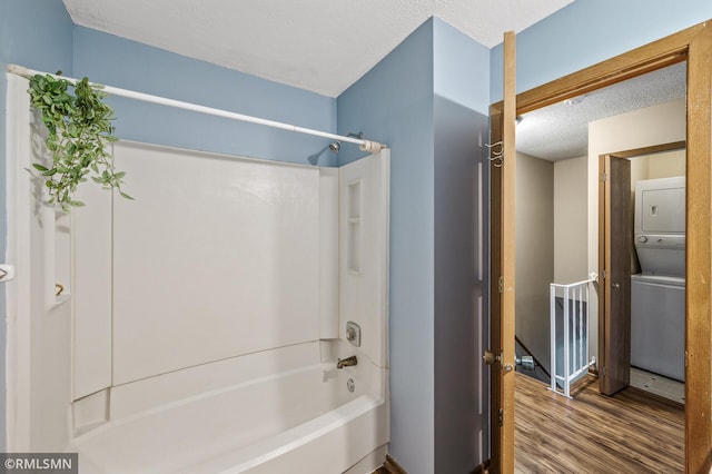 1111 Royal Oaks Dr, Shoreview, MN 55126 - bathroom with stacked washing machine and dryer, wood finished floors, bathtub / shower combination, and a textured ceiling
