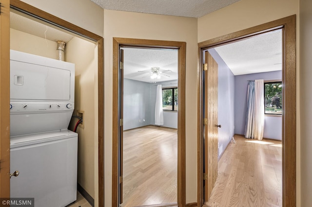1111 Royal Oaks Dr, Shoreview, MN 55126 - laundry area featuring stacked washer / dryer, a textured ceiling, light wood finished floors, and healthy amount of natural light