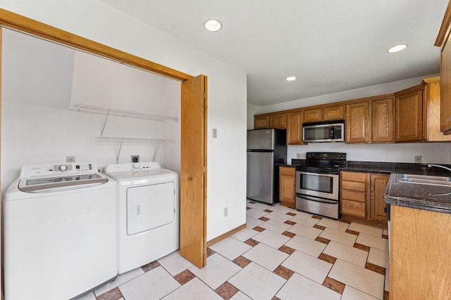 5071 Arrowood Ln N, Plymouth, MN 55442 - kitchen with appliances with stainless steel finishes, independent washer and dryer, dark countertops, recessed lighting, and brown cabinetry