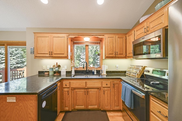 7111 Trenton Ln N, Maple Grove, MN 55369 - kitchen with stainless steel appliances, a peninsula, and dark stone countertops