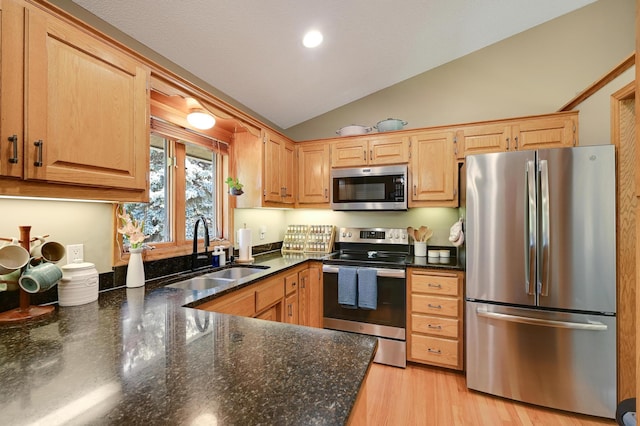 7111 Trenton Ln N, Maple Grove, MN 55369 - kitchen featuring stainless steel appliances, lofted ceiling, dark stone counters, light wood-type flooring, and light brown cabinets